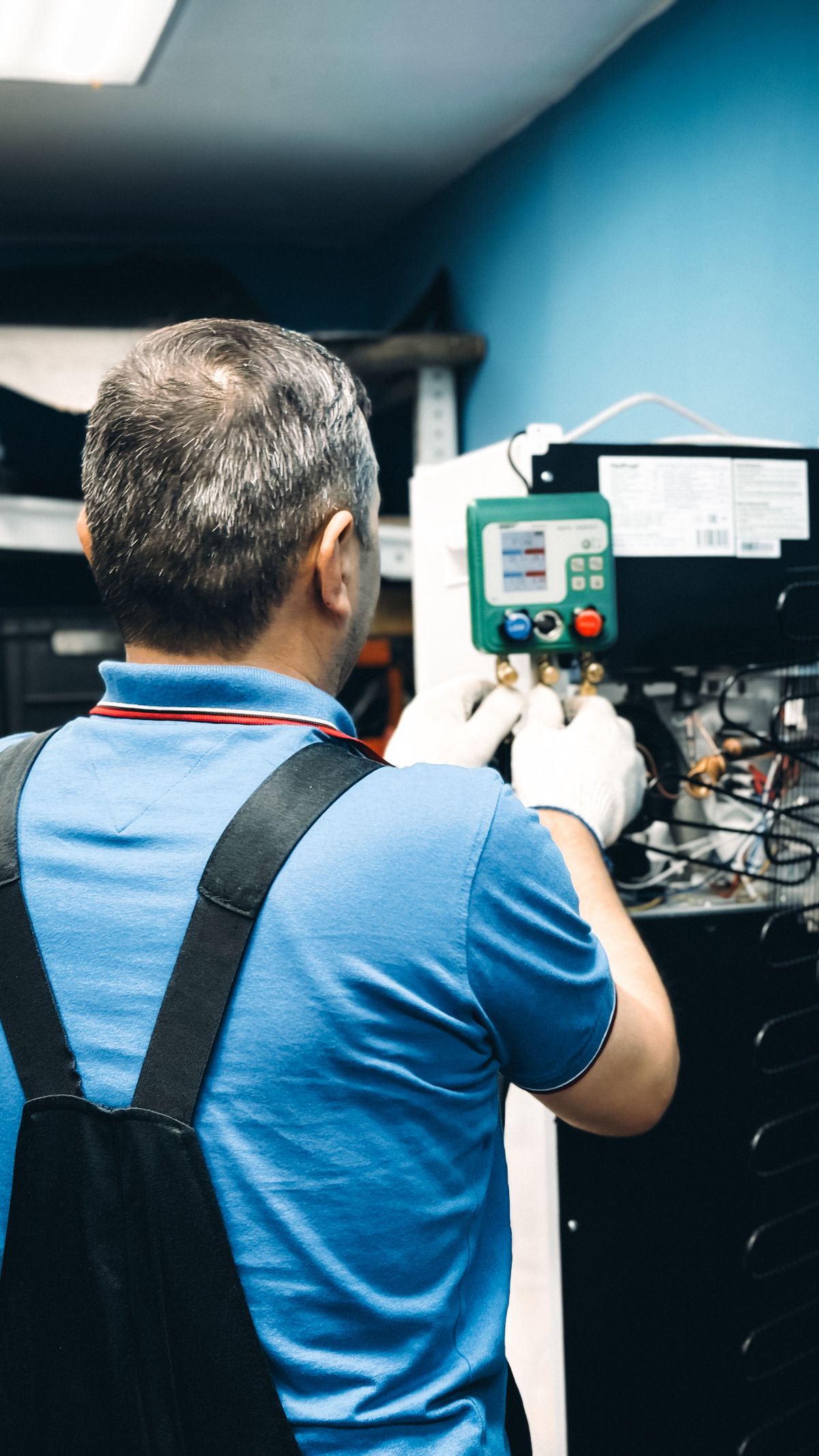 Um técnico a verificar um sistema com manómetros de refrigerante